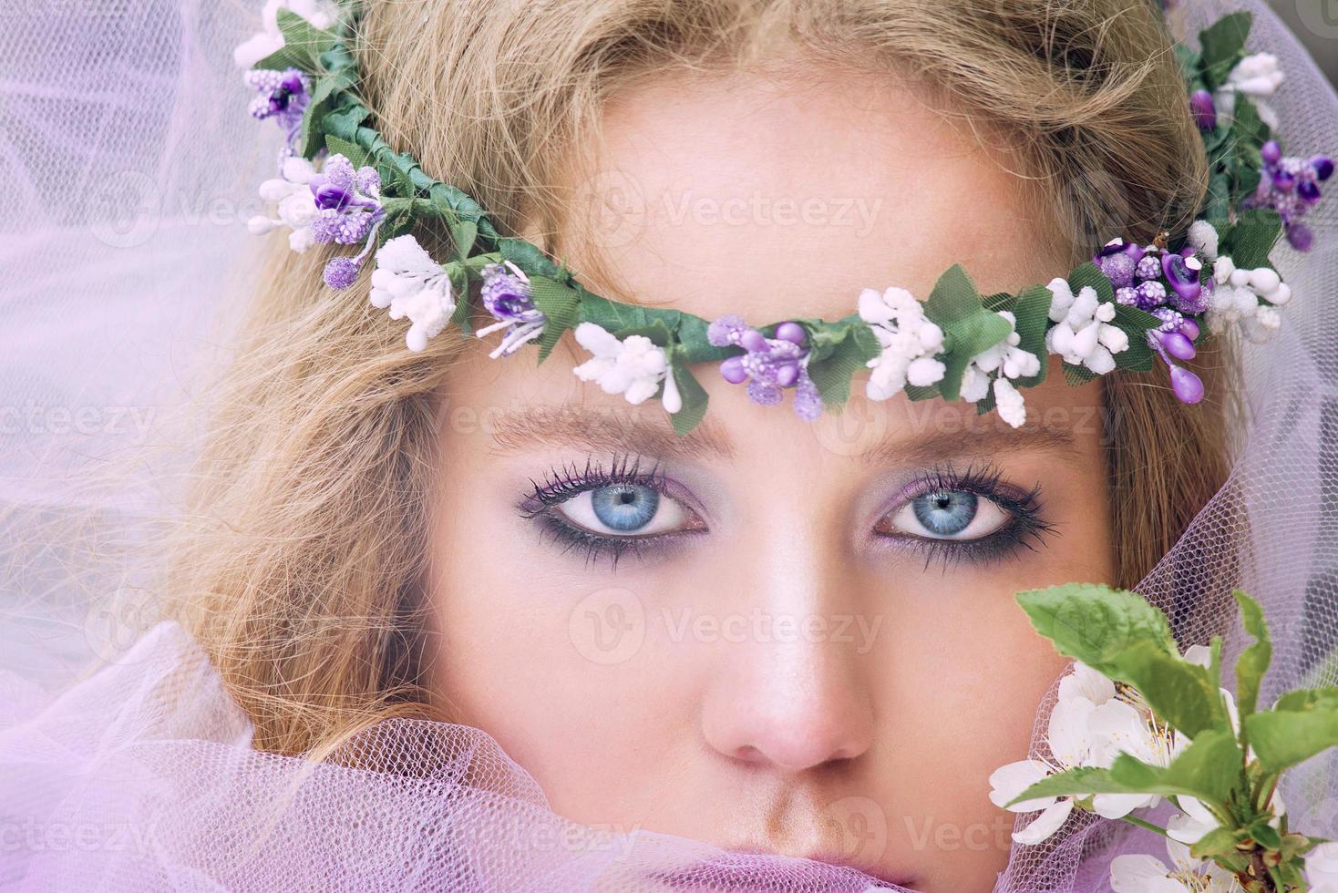 belle jeune femme blonde en couronne de fleurs arbres en fleurs au printemps photo