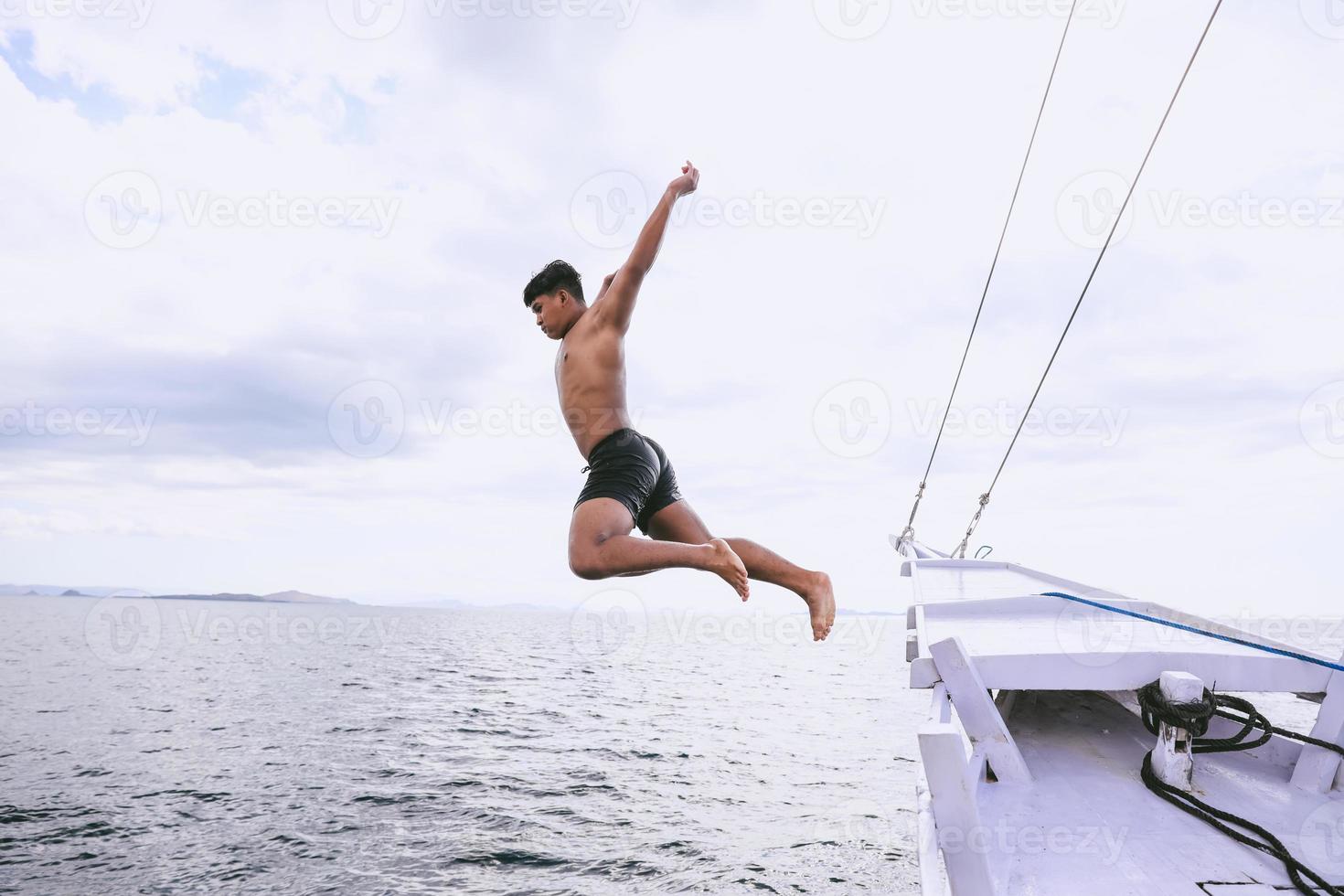 homme courageux sautant dans la mer depuis un bateau photo