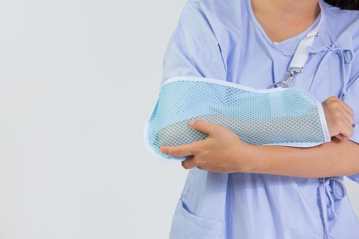 jeune femme avec un bras cassé portant une attelle de bras sur fond blanc photo