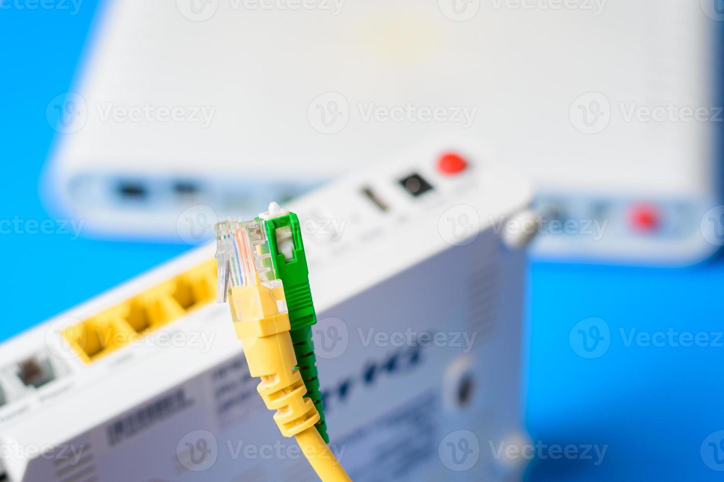 câbles à fibres optiques et réseau avec routeur sans fil internet sur fond bleu photo