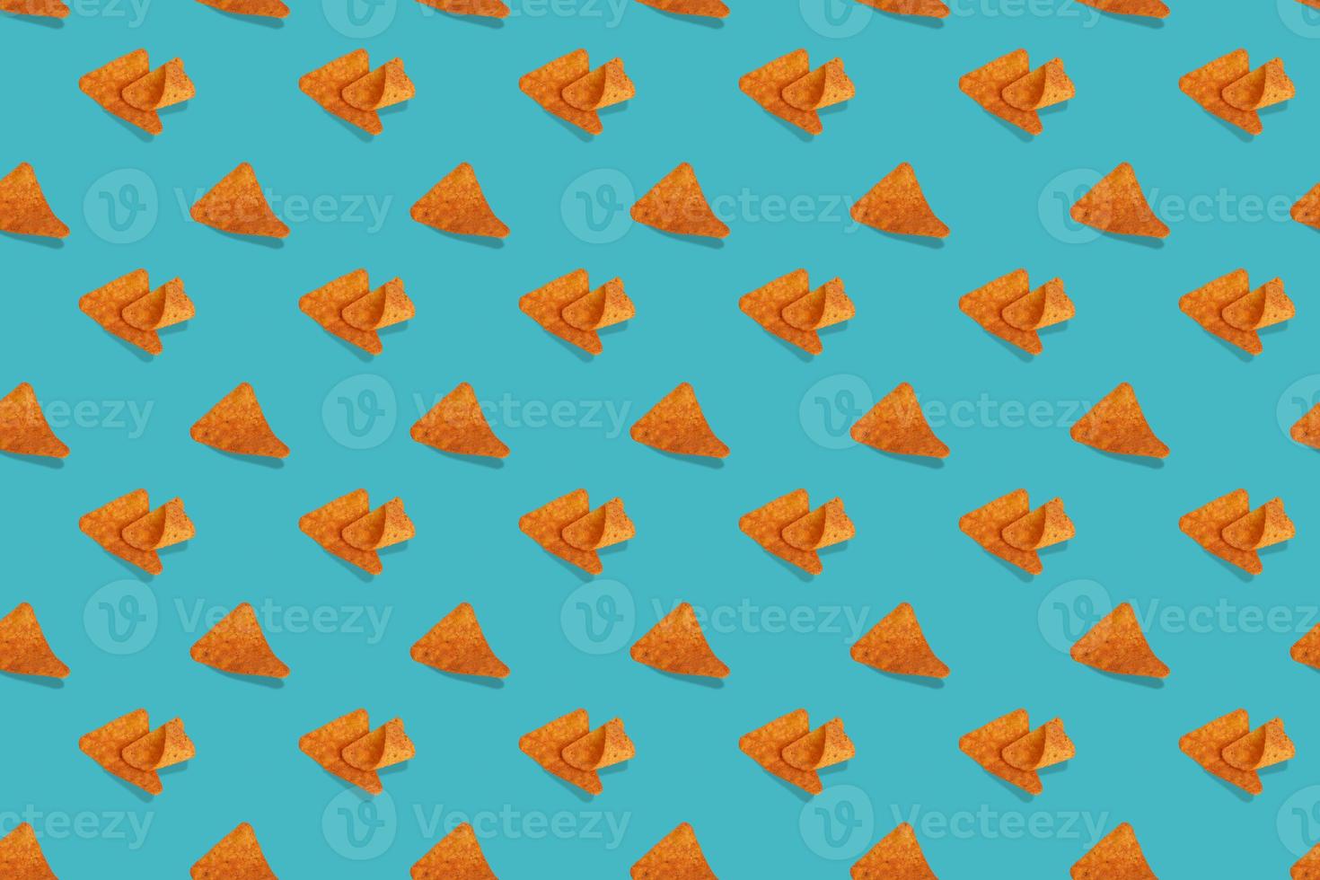 nachos chips de maïs modèle sans couture sur fond bleu. photo