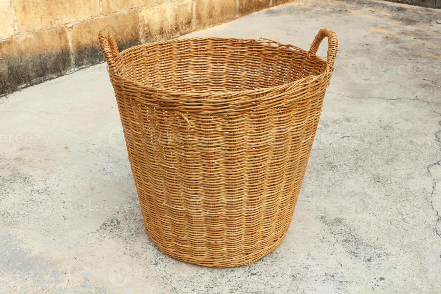 panier en osier vide sur le vieux sol en béton et mur de briques. photo