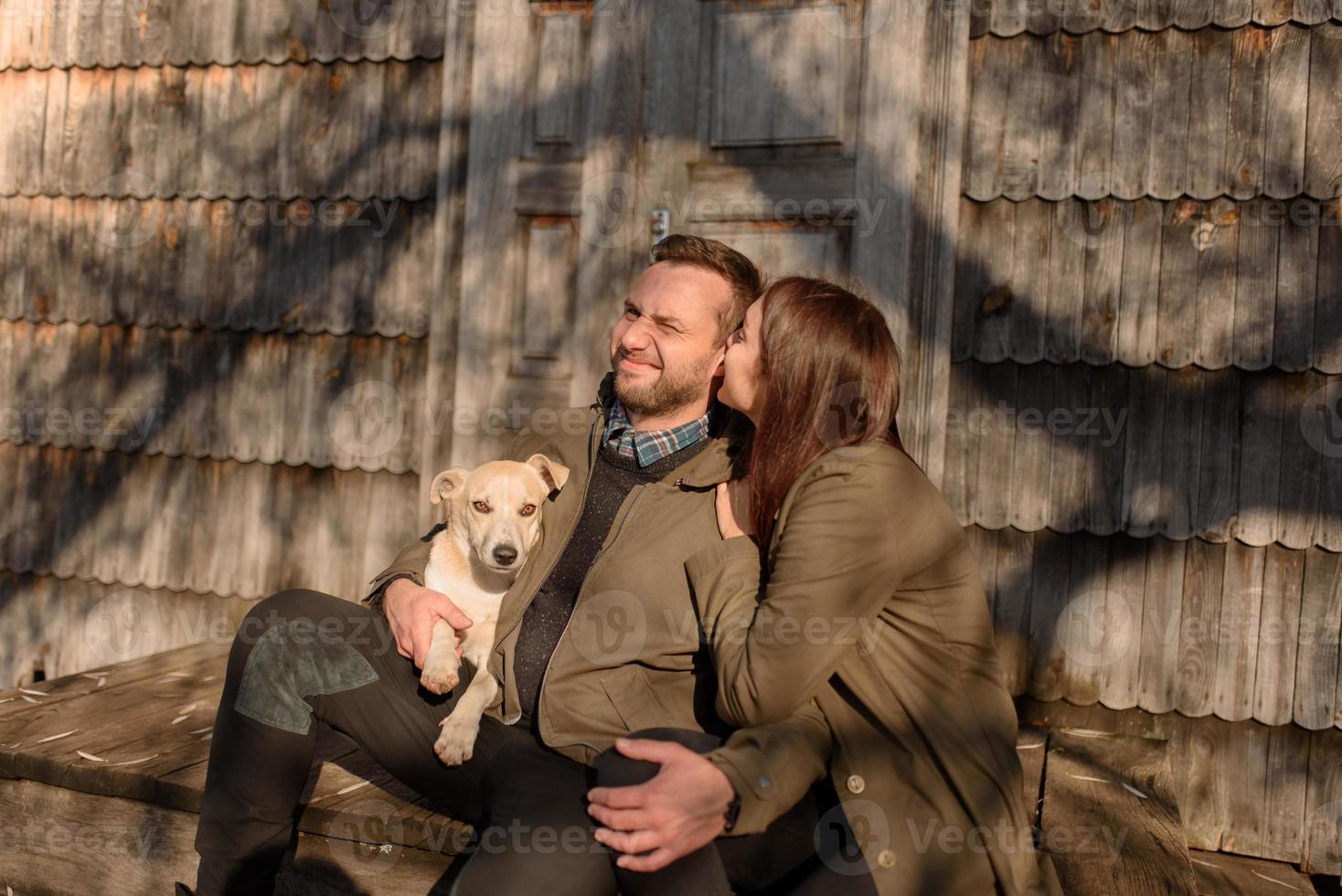 beau couple passant la journée d'automne à l'extérieur avec leur chien photo