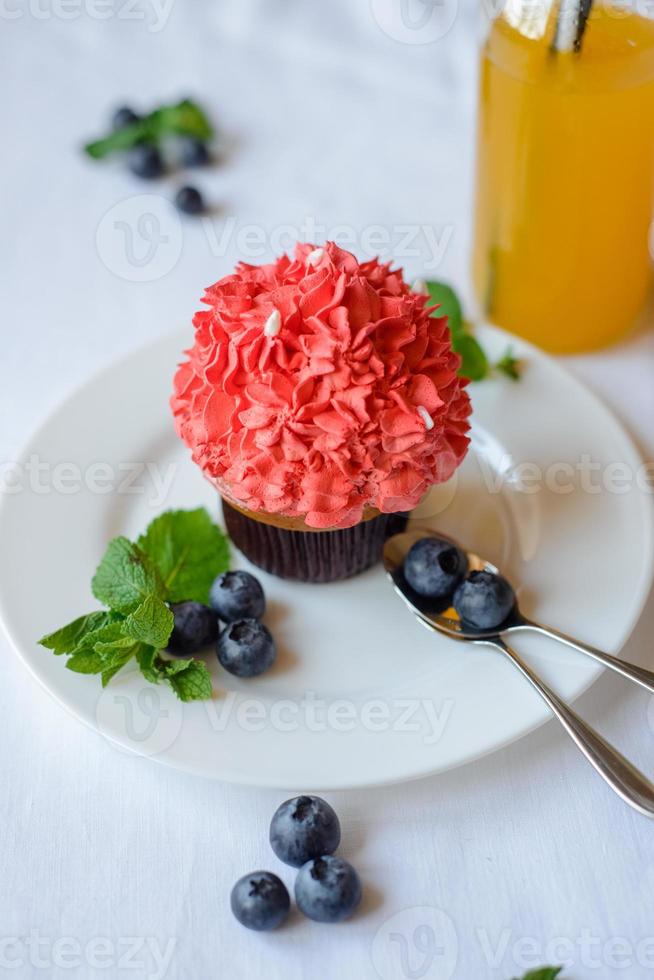 délicieux cupcake sur une plaque blanche sur fond blanc. photo