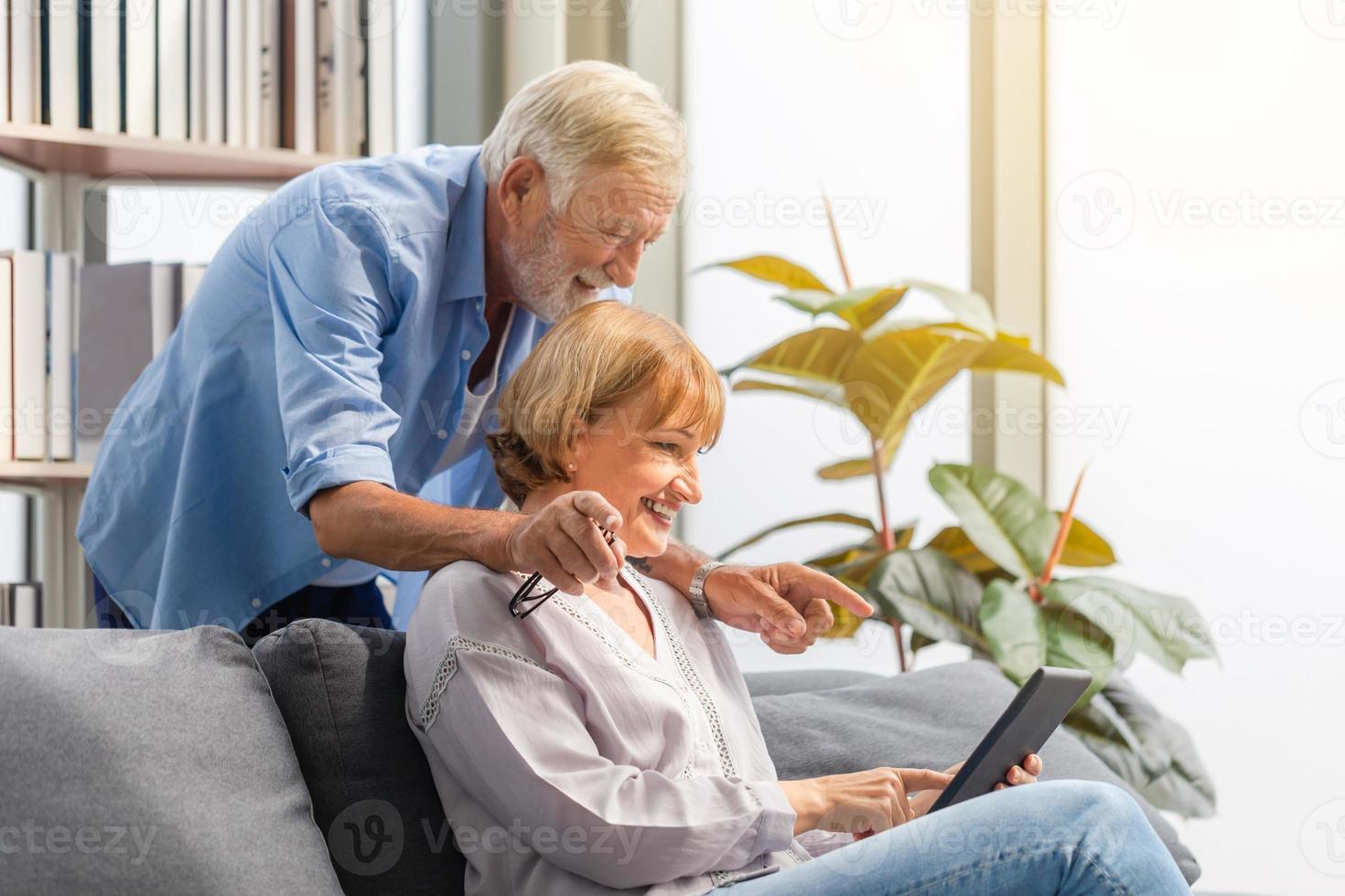 portrait d'un couple de personnes âgées heureux dans le salon, d'une femme âgée et d'un homme utilisant un téléphone intelligent parlant par appel vidéo sur un canapé confortable à la maison, concepts de famille heureuse photo