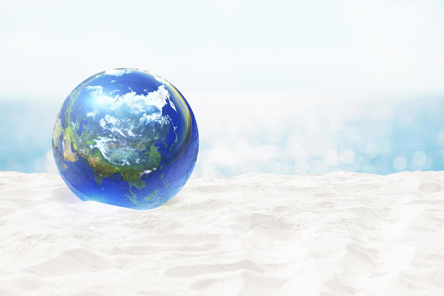 boule de verre de terre sur la plage de bord de mer de l'océan et belle plage de sable blanc et flou beau nuage sur ciel bleu en mer .éléments de cette image fournis par la nasa photo