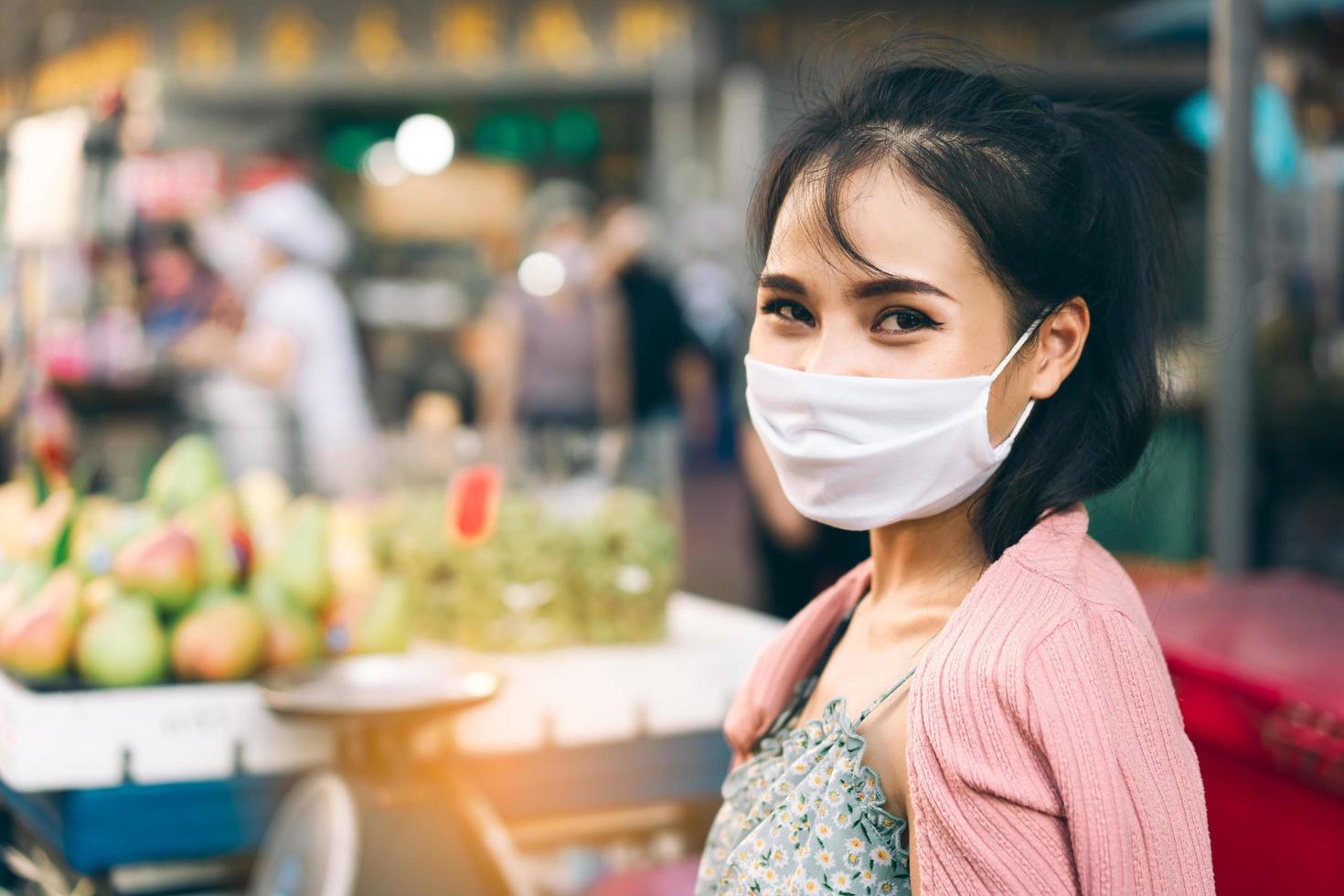 femme adulte asiatique heureuse peau bronzée porter un masque sur le visage pour une nouvelle normalité. photo