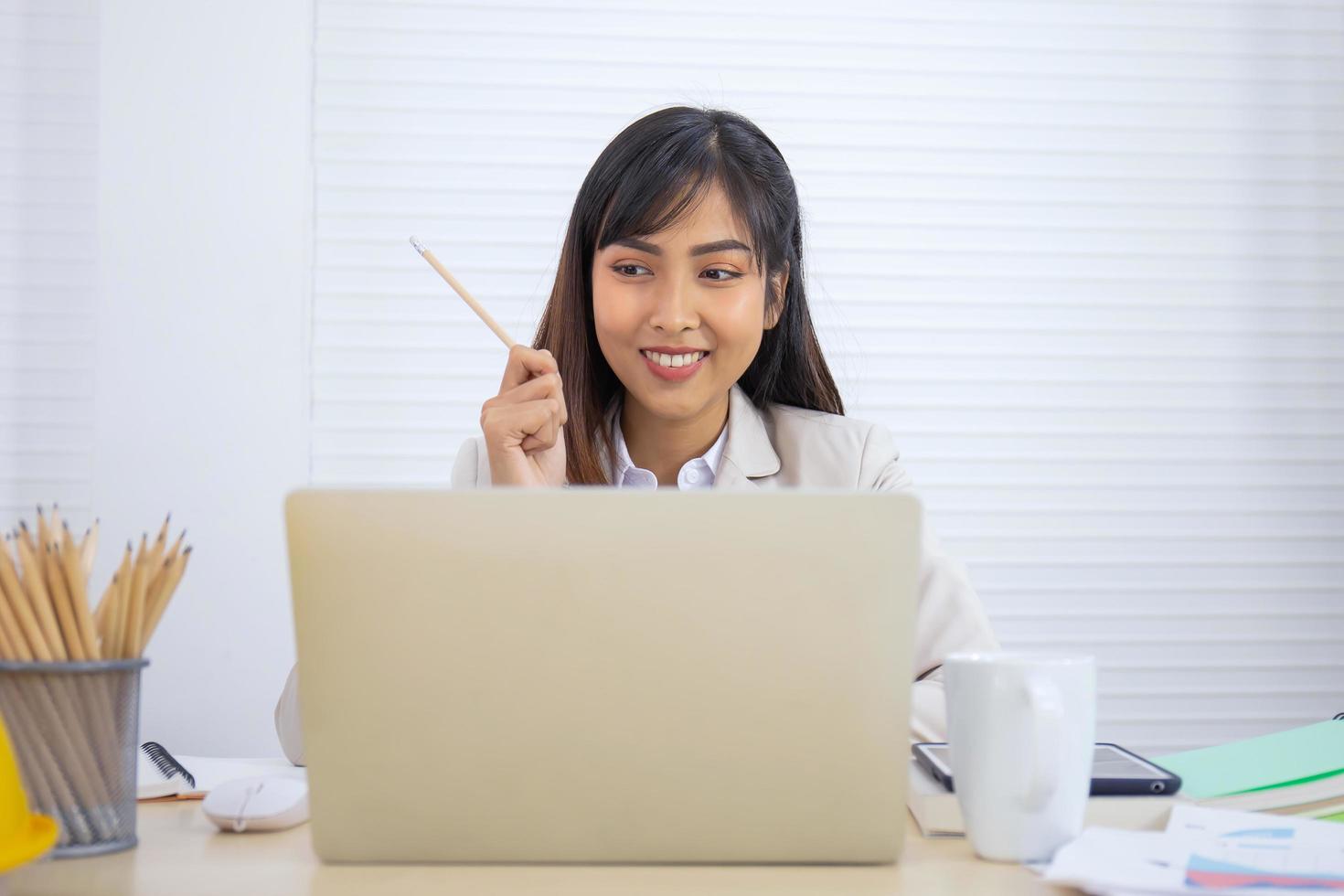 une jeune femme d'affaires professionnelle asiatique dort sur son bureau. photo