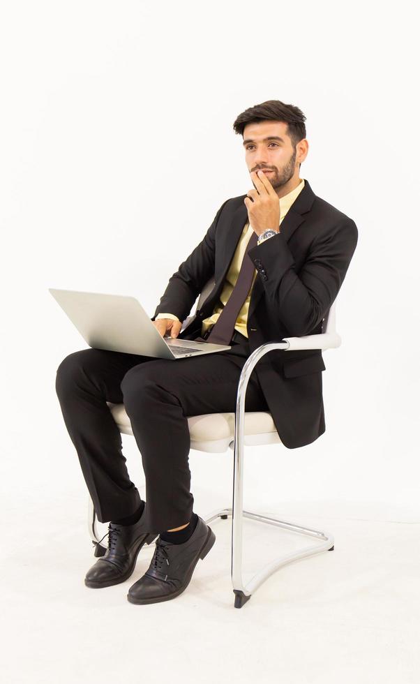 un bel homme d'affaires masculin est idéalement assis sur une chaise et a une tablette isolée sur fond blanc, photo