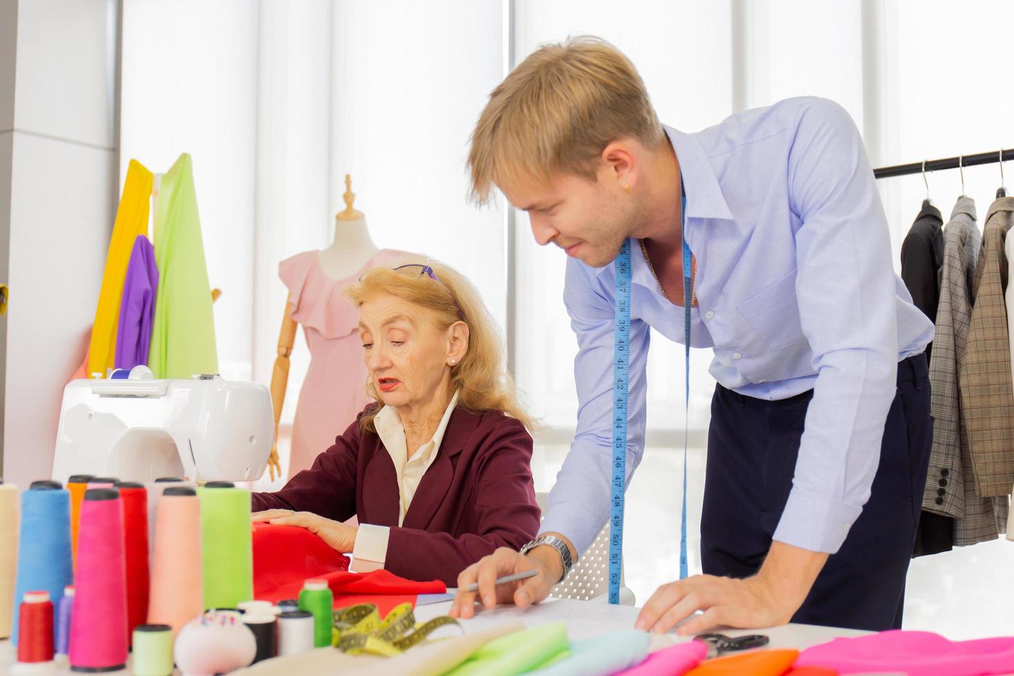 designers professionnels, jeunes hommes et femmes plus âgées au bureau avec une variété de tons de tissus et d'accessoires pour différents designs. photo