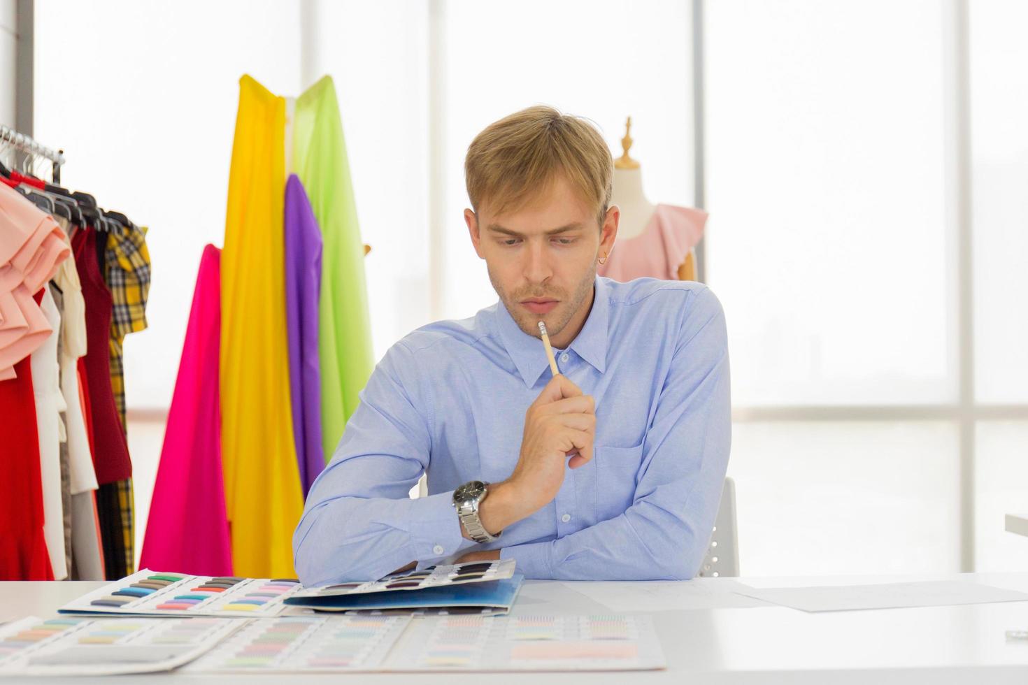 Les concepteurs de couture masculins professionnels au bureau ont une variété de combinaisons de couleurs de tissu. photo