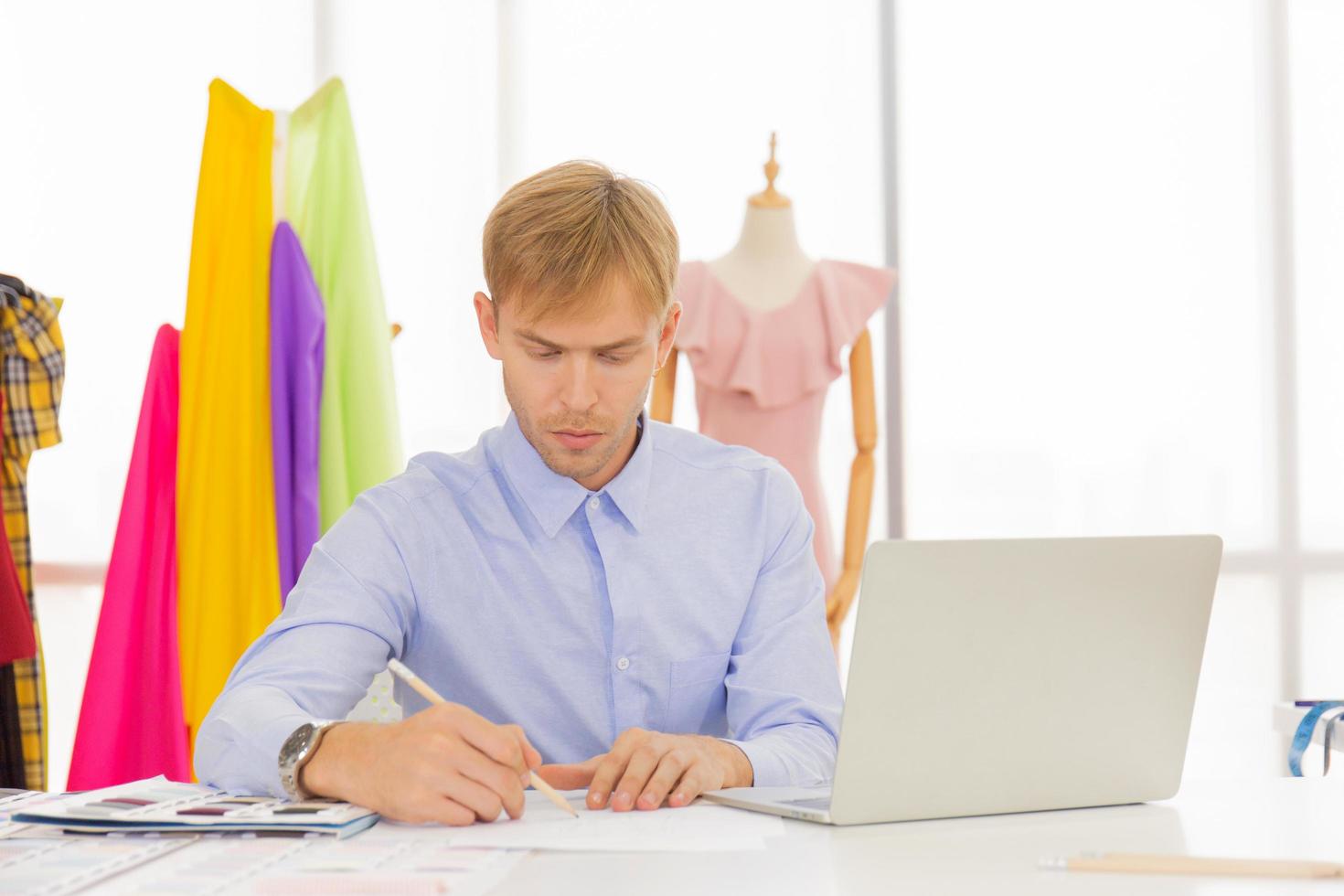 Les concepteurs de couture masculins professionnels au bureau ont une variété de combinaisons de couleurs de tissu. photo