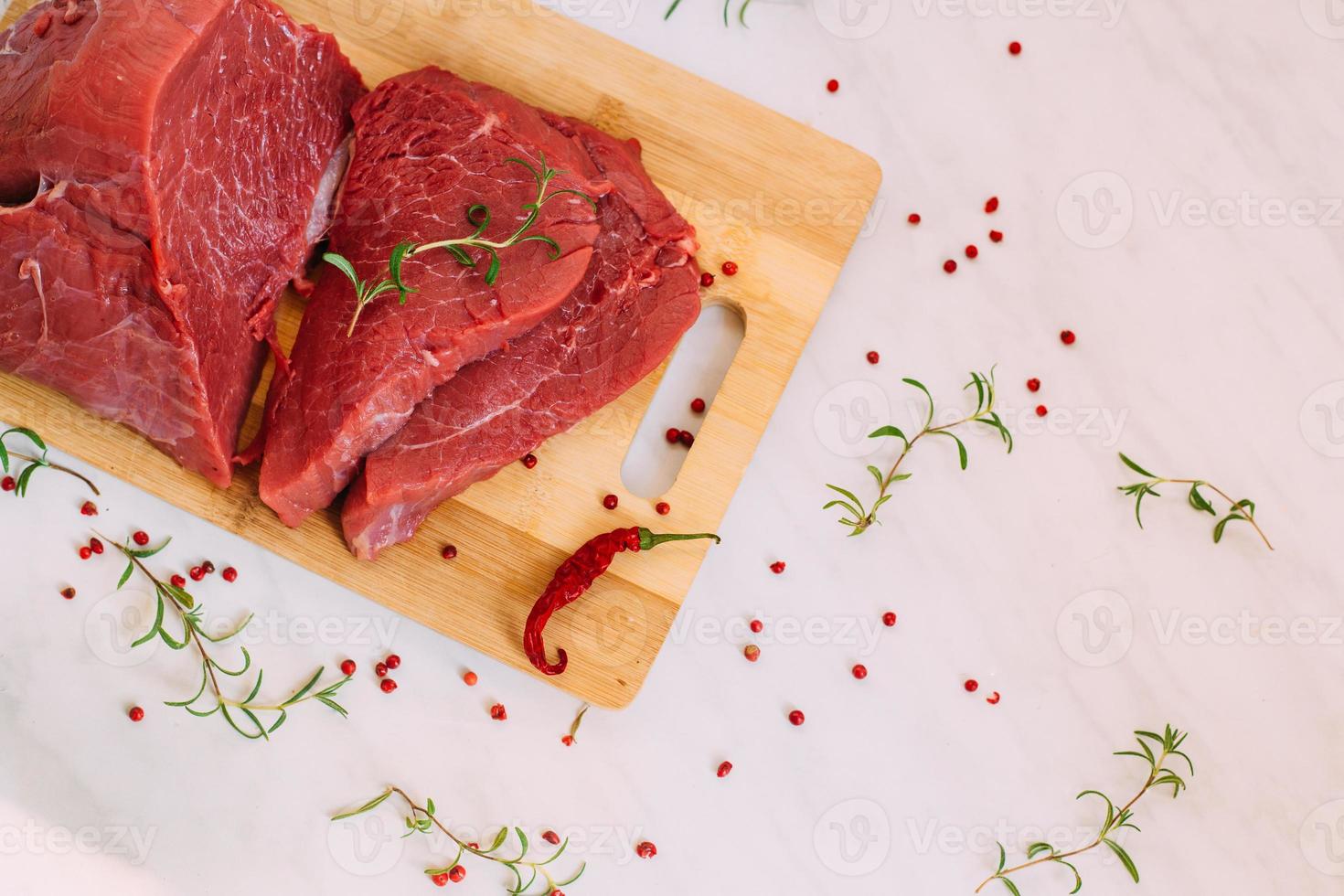 filet cru de porc frais sur planche de bois. viande de boeuf rouge sur une planche à découper. photo