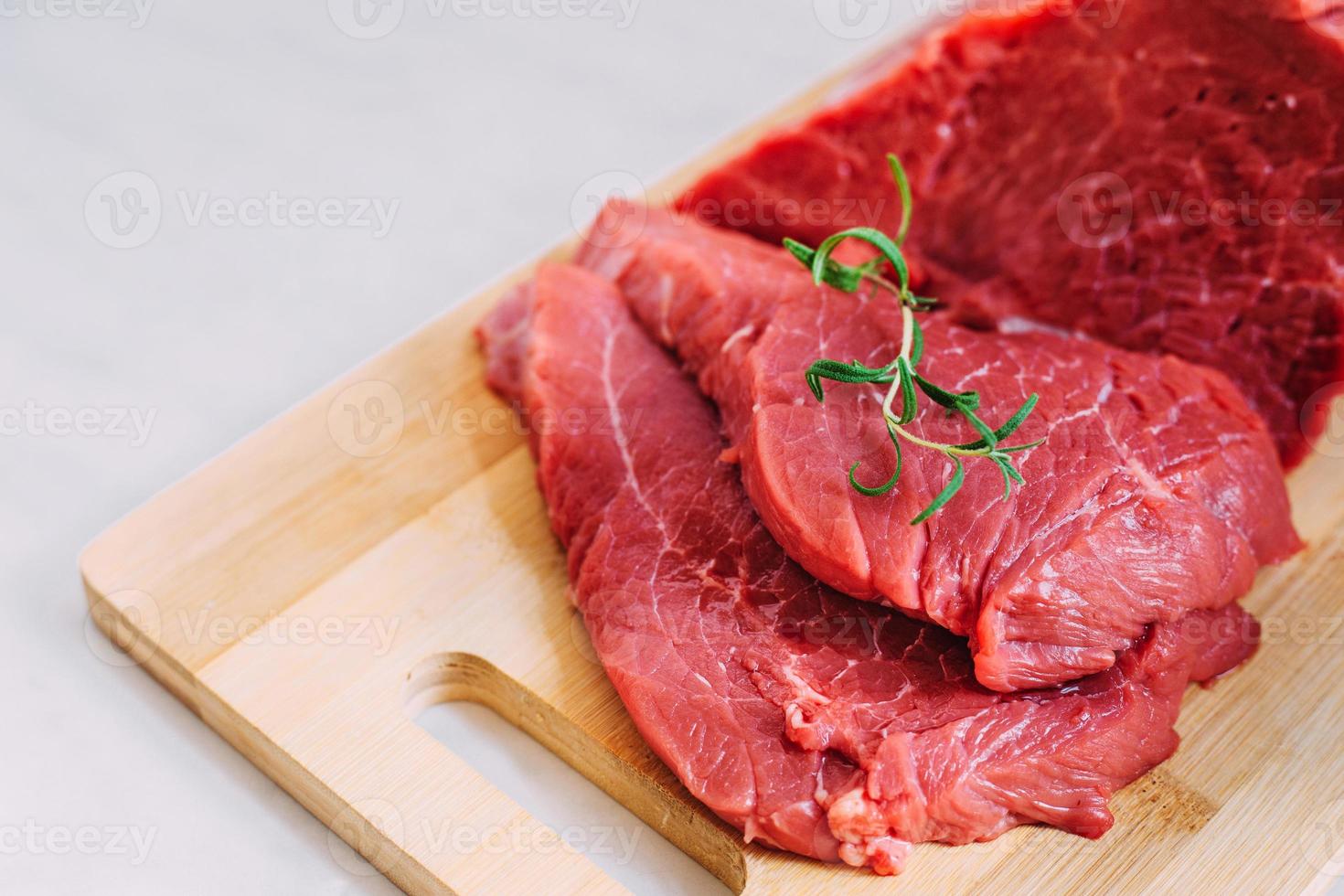 filet cru de porc frais sur planche de bois. viande de boeuf rouge sur une planche à découper. photo