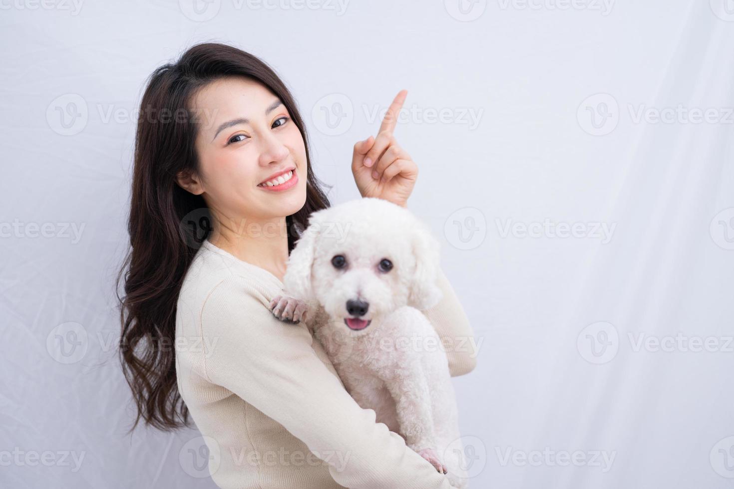 jeune femme asiatique étreignant son chien sur fond blanc photo