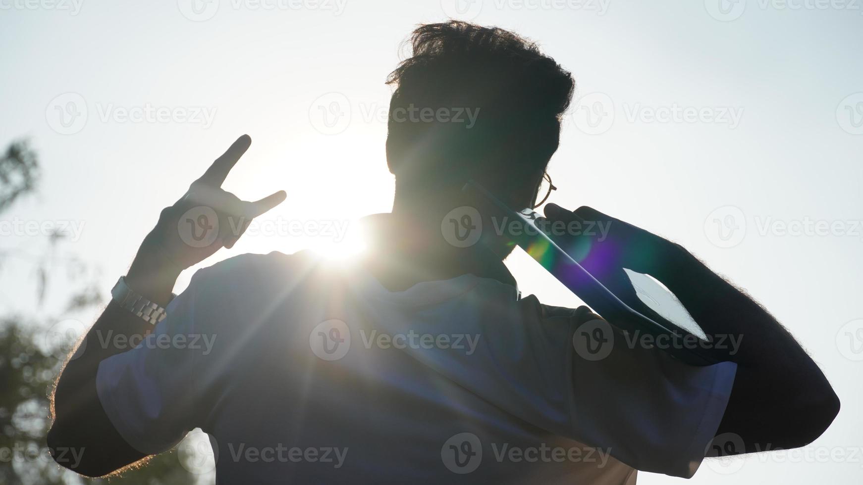 le jeune homme lève les bras sur un pic. avoir un ordinateur portable et le bonheur et l'excitation de réussir. personne heureuse après sa sélection dans le travail et heureuse et excitée pour le travail photo