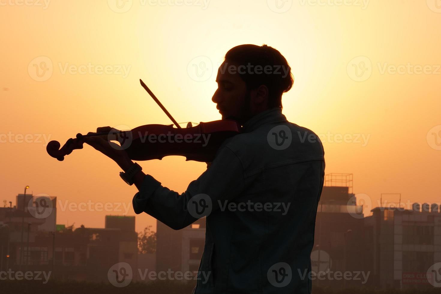 musicien jouant du violon. concept de musique et de tonalité musicale. images de silhouette de musicien homme photo