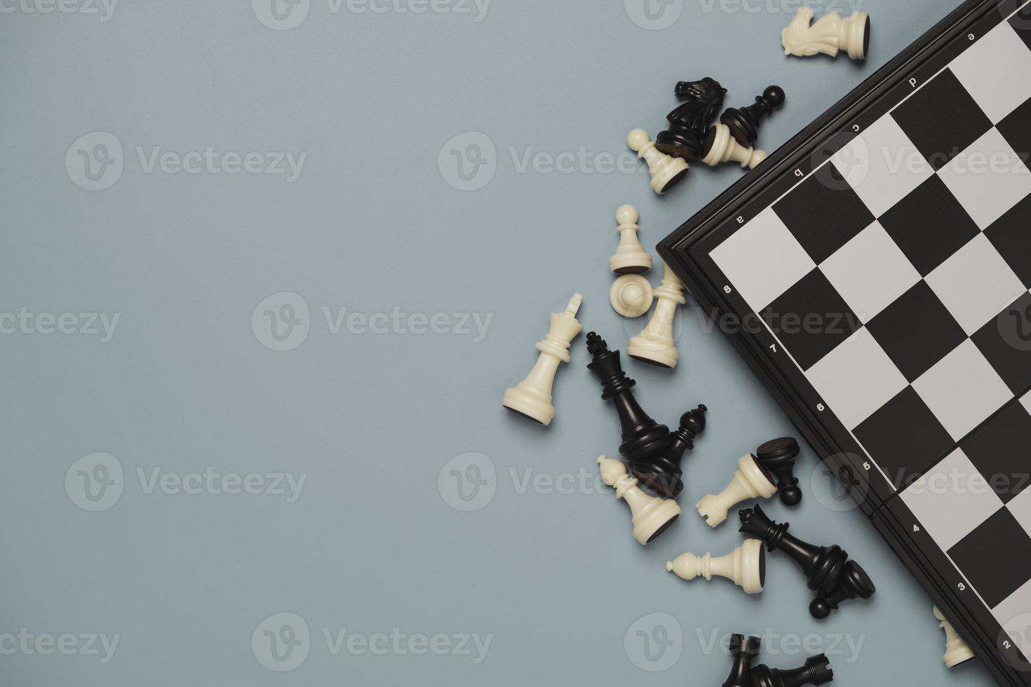 vue de dessus des pièces d'échecs avec échiquier sur fond bleu pour le concept de stratégie de loisirs et d'affaires. photo