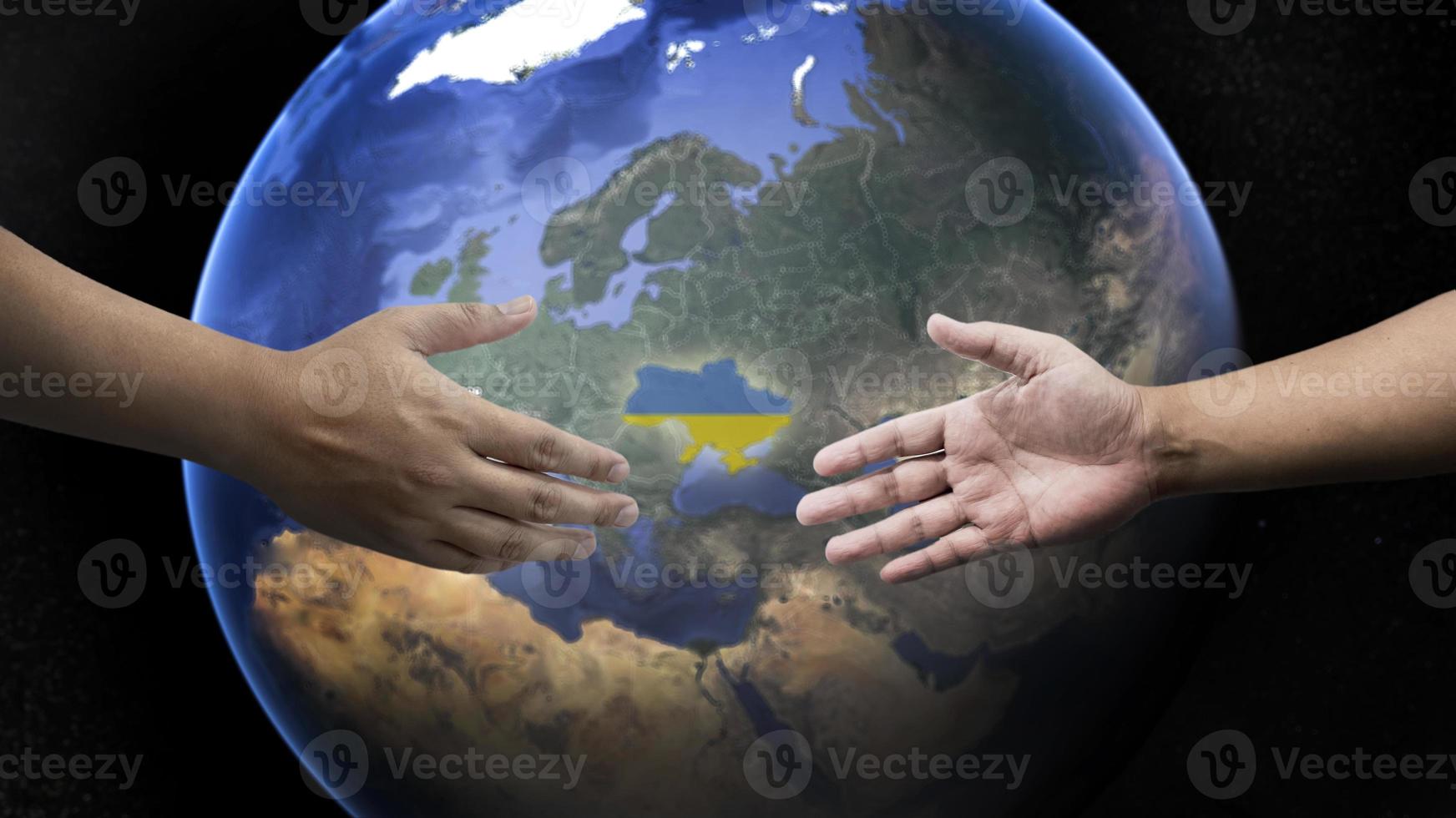 tendant la main pour unir la russie et l'ukraine pour faire la paix sur le fond de la terre. photo