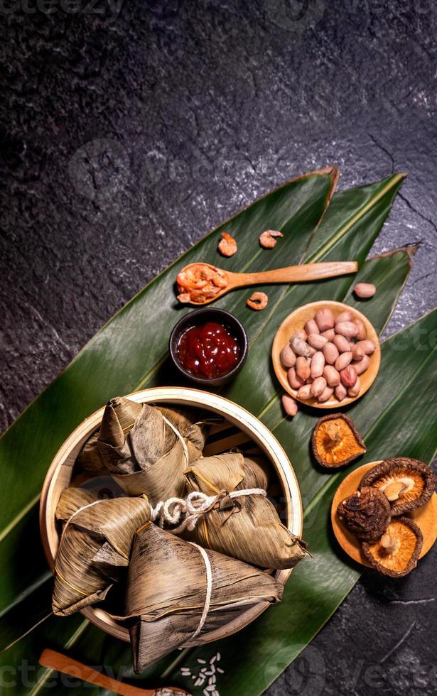 gros plan, espace de copie, vue de dessus, mise à plat. célèbre cuisine asiatique chinoise savoureuse faite à la main dans l'événement duan wu, boulettes de riz cuites à la vapeur en forme d'ingrédient pyramidal sur ardoise noire photo