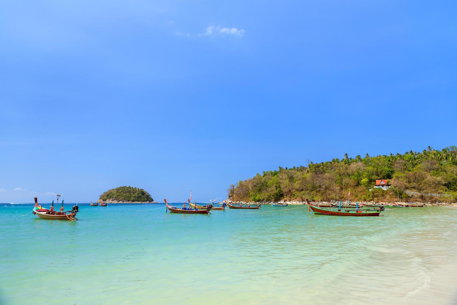 mer bleu turquoise cristalline et bateau de pêche en bois traditionnel à la plage de kata, phuket, thaïlande photo