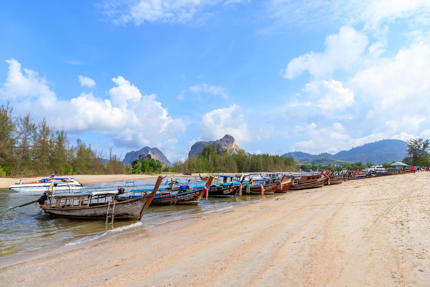 les touristes se préparent à embarquer des bateaux à la jetée de noppharat thara près de la plage de railay pour la visite des îles. photo