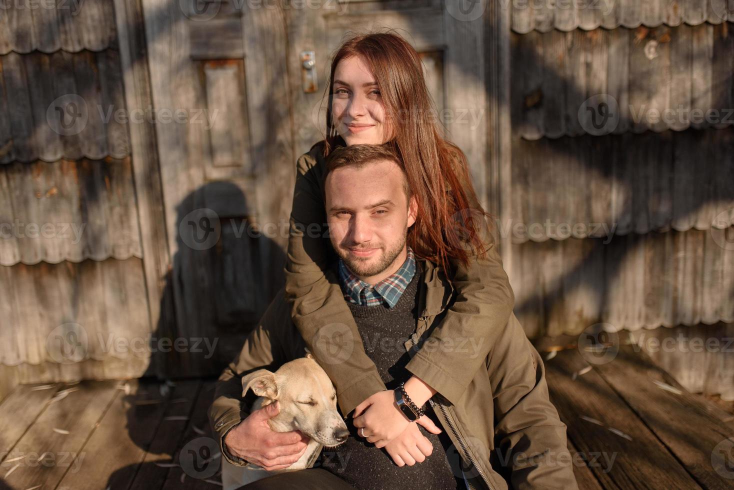 beau couple passant la journée d'automne à l'extérieur avec leur chien photo