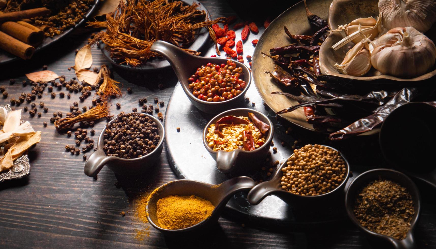 condiments ou épices pour le curry rouge ou la cuisine thaïlandaise. ingrédients épices alimentaires poivre, graines de coriandre, piments séchés, curcuma, ail. photo