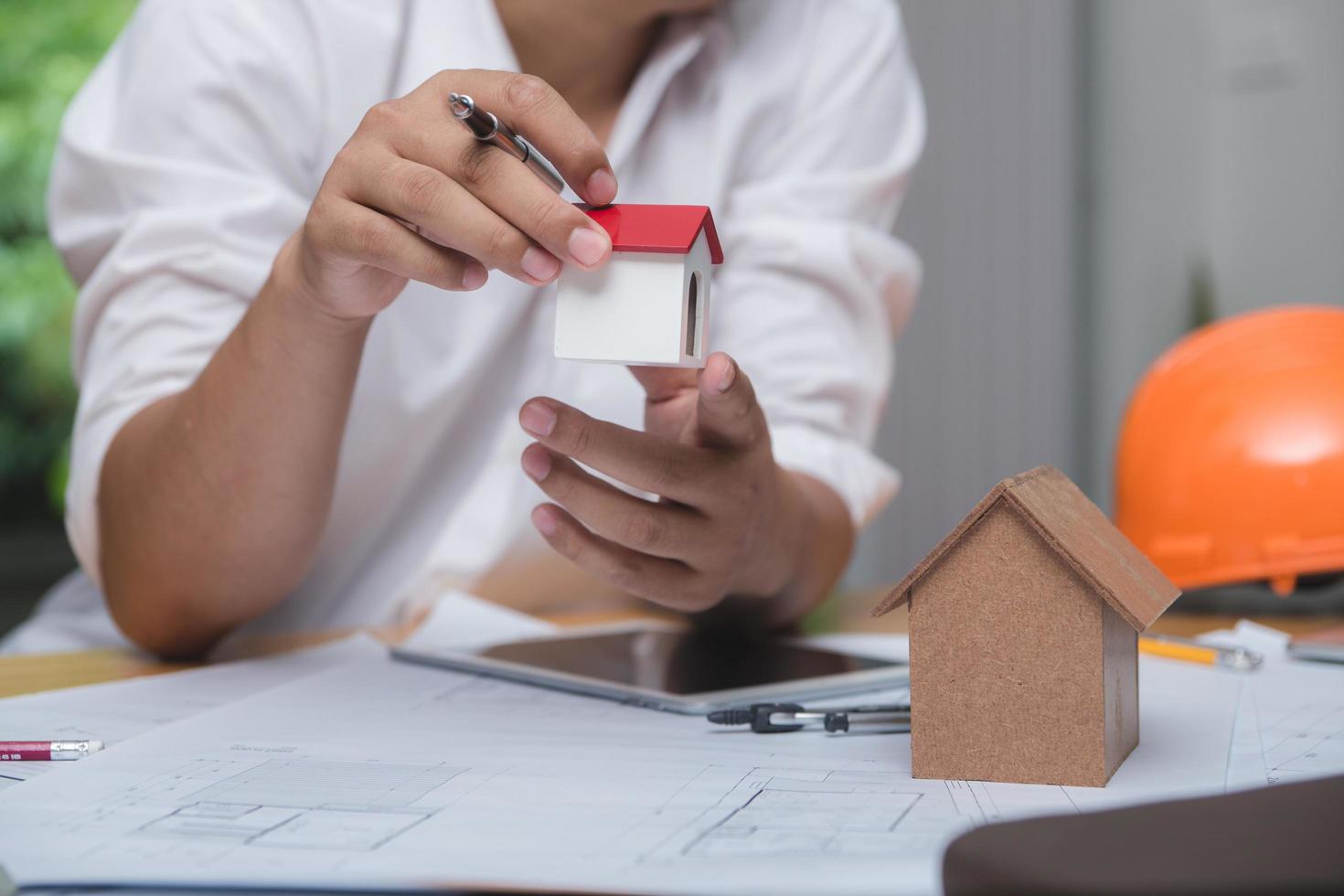 équipe d'architectes ou d'ingénieurs discutant sur le bureau avec un plan sur le nouveau projet de démarrage sur le bureau. groupe d'équipe sur le site de construction vérifier les documents et le flux de travail d'entreprise. mise au point sélective. photo