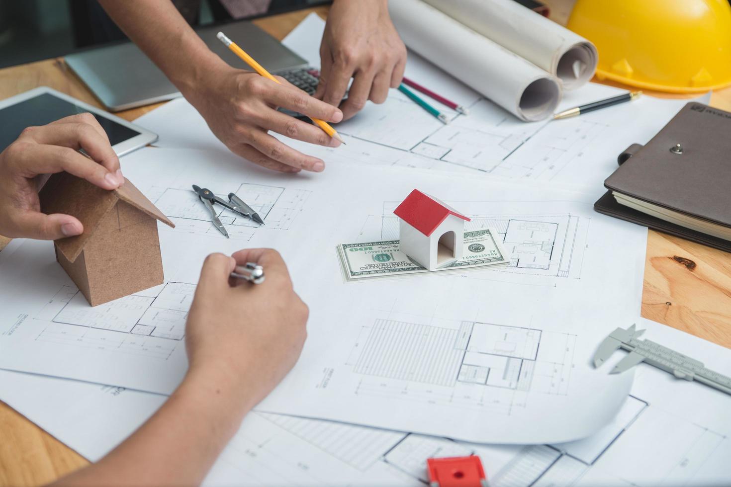 équipe d'architectes ou d'ingénieurs discutant sur le bureau avec un plan sur le nouveau projet de démarrage sur le bureau. groupe d'équipe sur le site de construction vérifier les documents et le flux de travail d'entreprise. mise au point sélective. photo