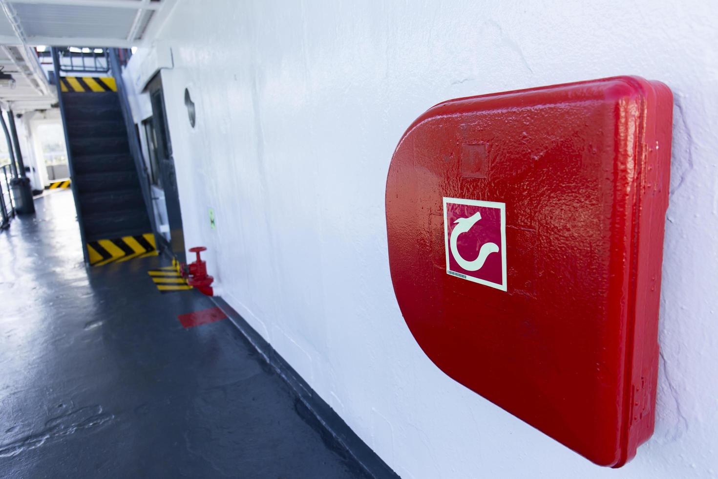 enrouleur de tuyau d'incendie rouge fixé au mur sur le bateau. photo