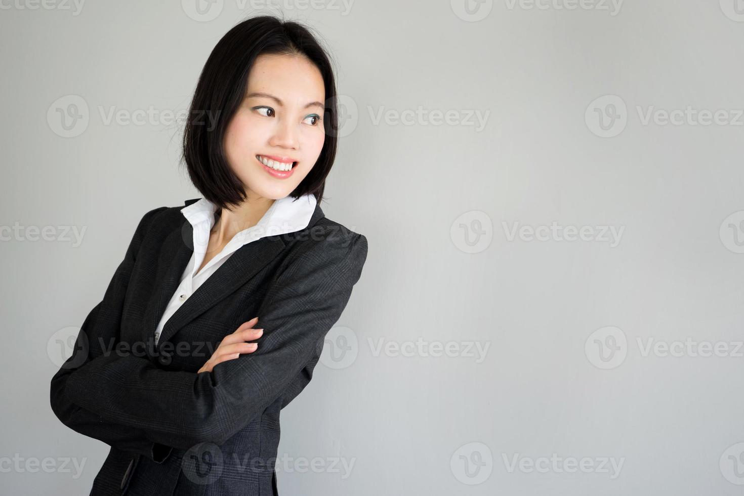 Portrait jeune femme d'affaires debout sur fond gris photo