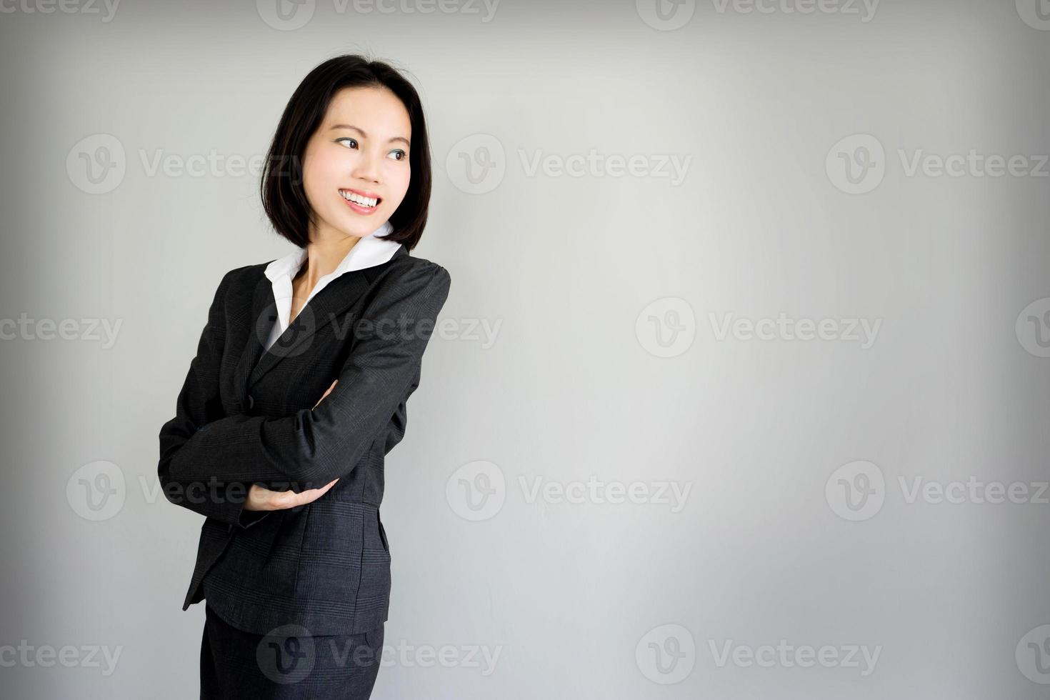 Portrait jeune femme d'affaires debout sur fond gris photo