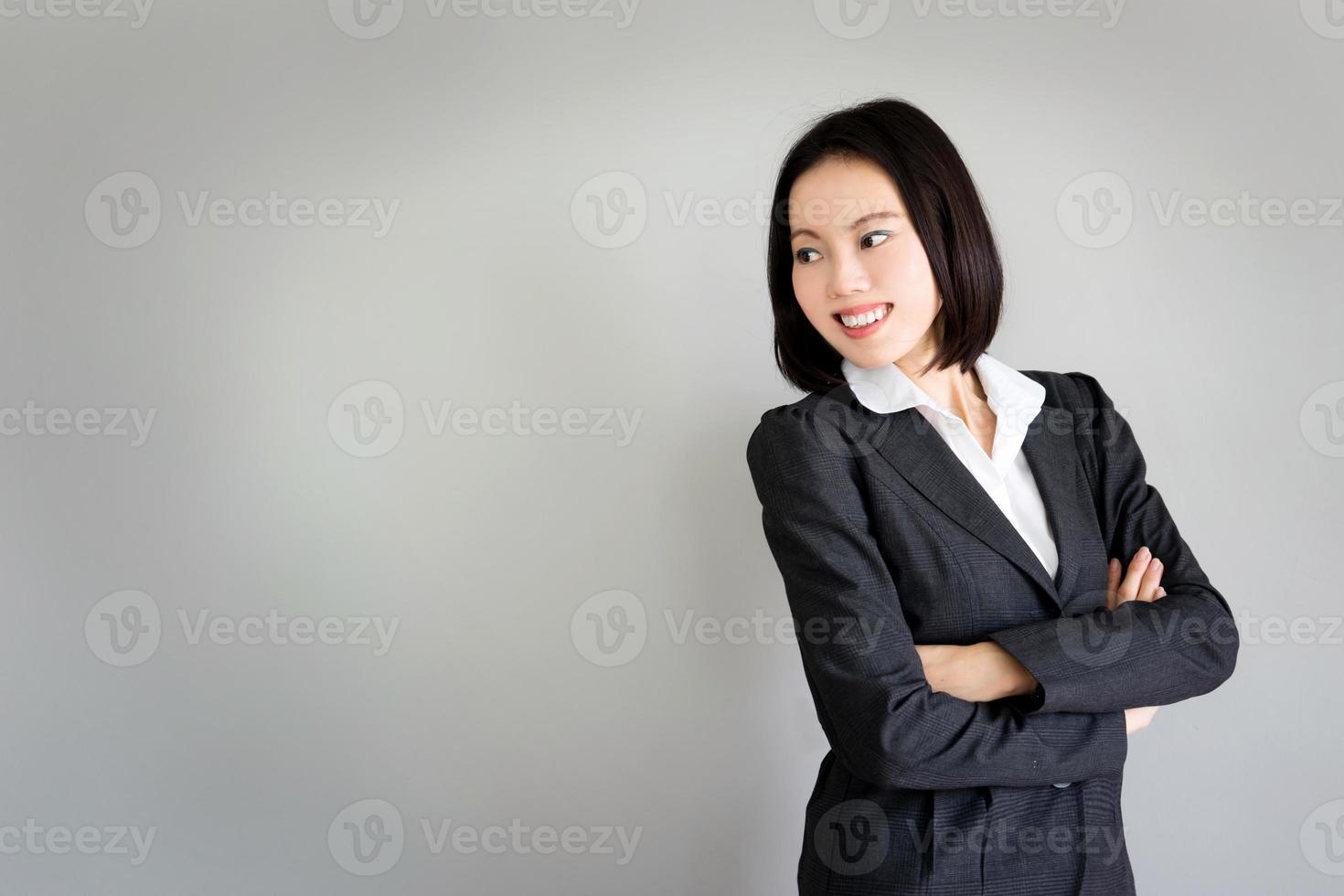 Portrait jeune femme d'affaires debout sur fond gris photo