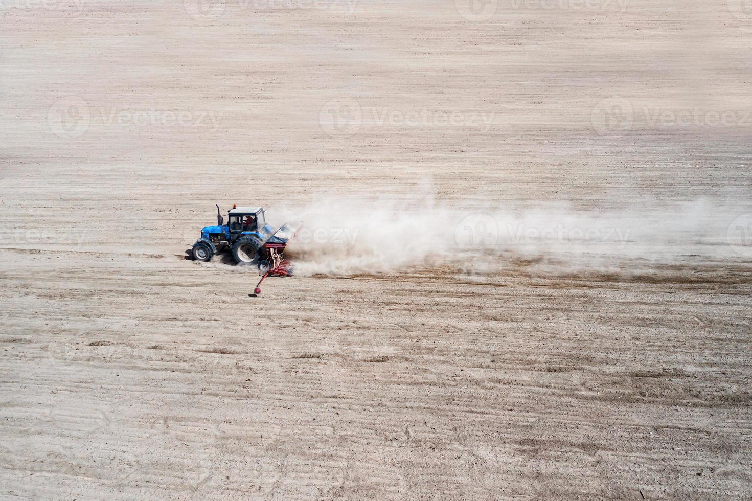 vue latérale du tracteur industriel agricole laboure le champ de sol pour l'ensemencement, vue aérienne. culture de la terre. photo