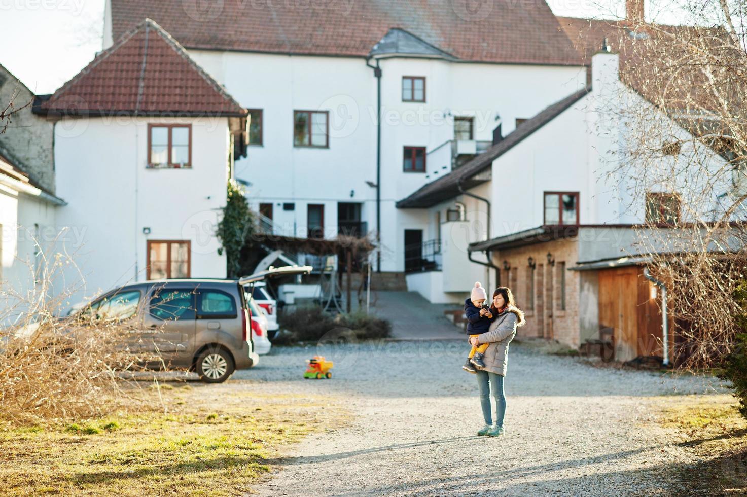 mère tient sa fille sur les mains dans l'arrière-cour. photo