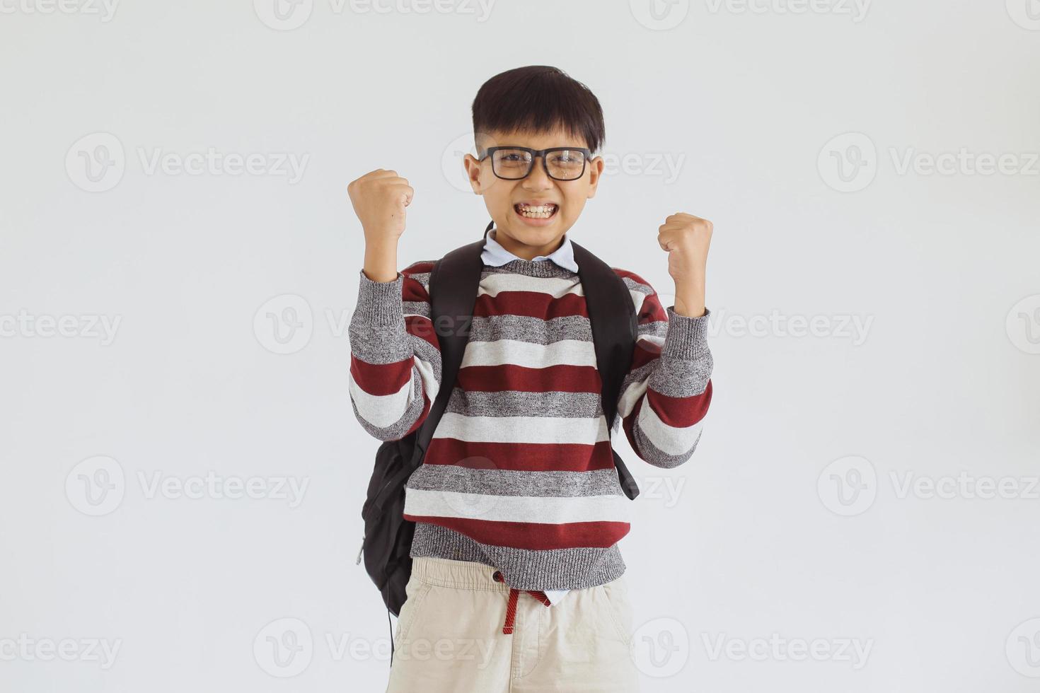 heureux enfant asiatique de l'école élémentaire excité en faisant un geste de victoire photo