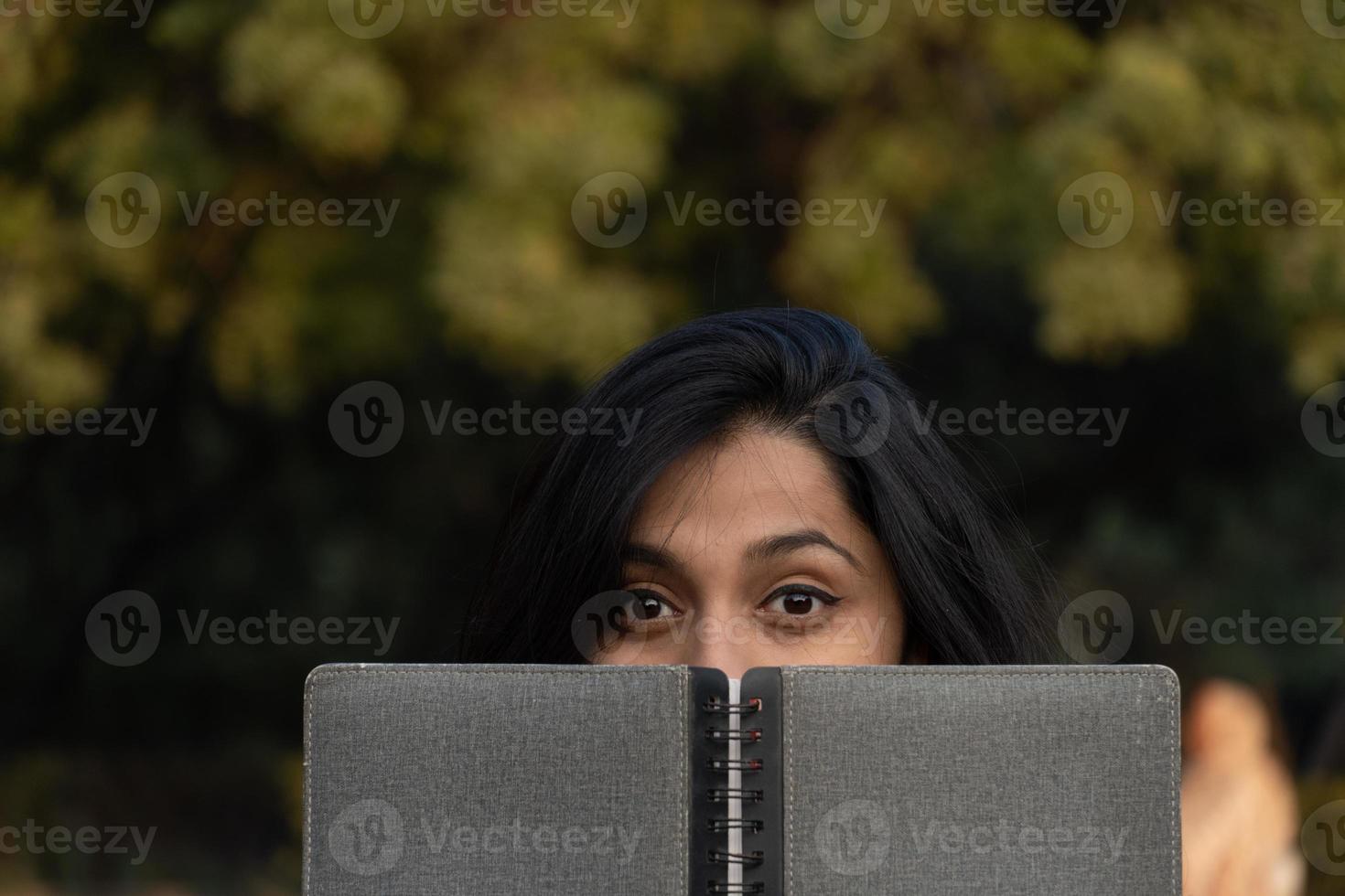 jeune étudiante avec journal près de ses yeux photo