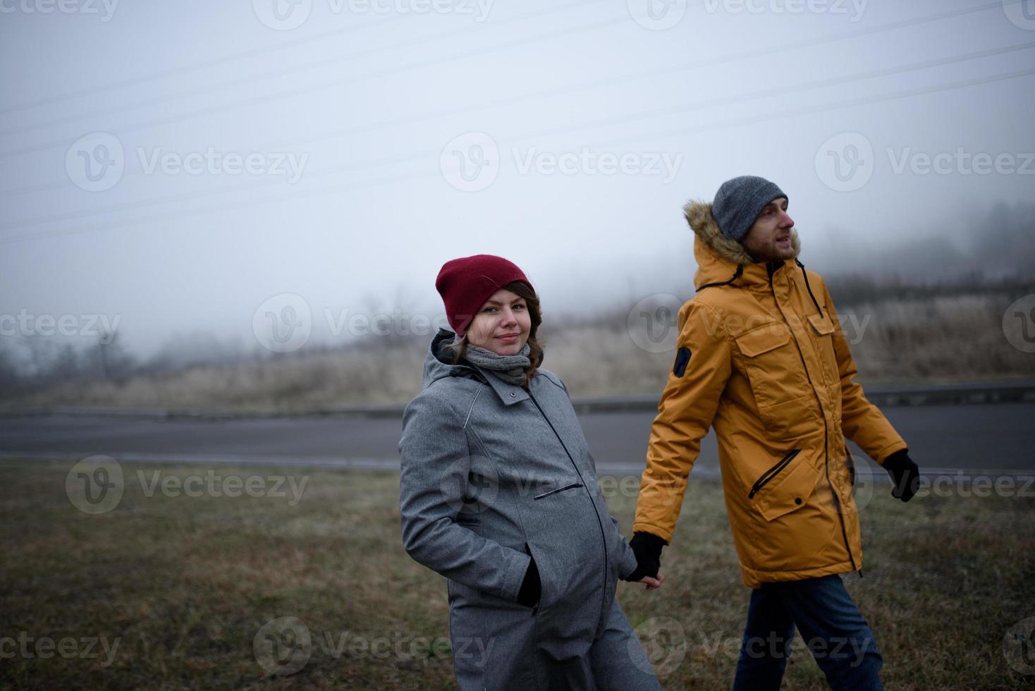 un couple enceinte aimant se promène à l'extérieur de la ville à la fin de l'automne. photo