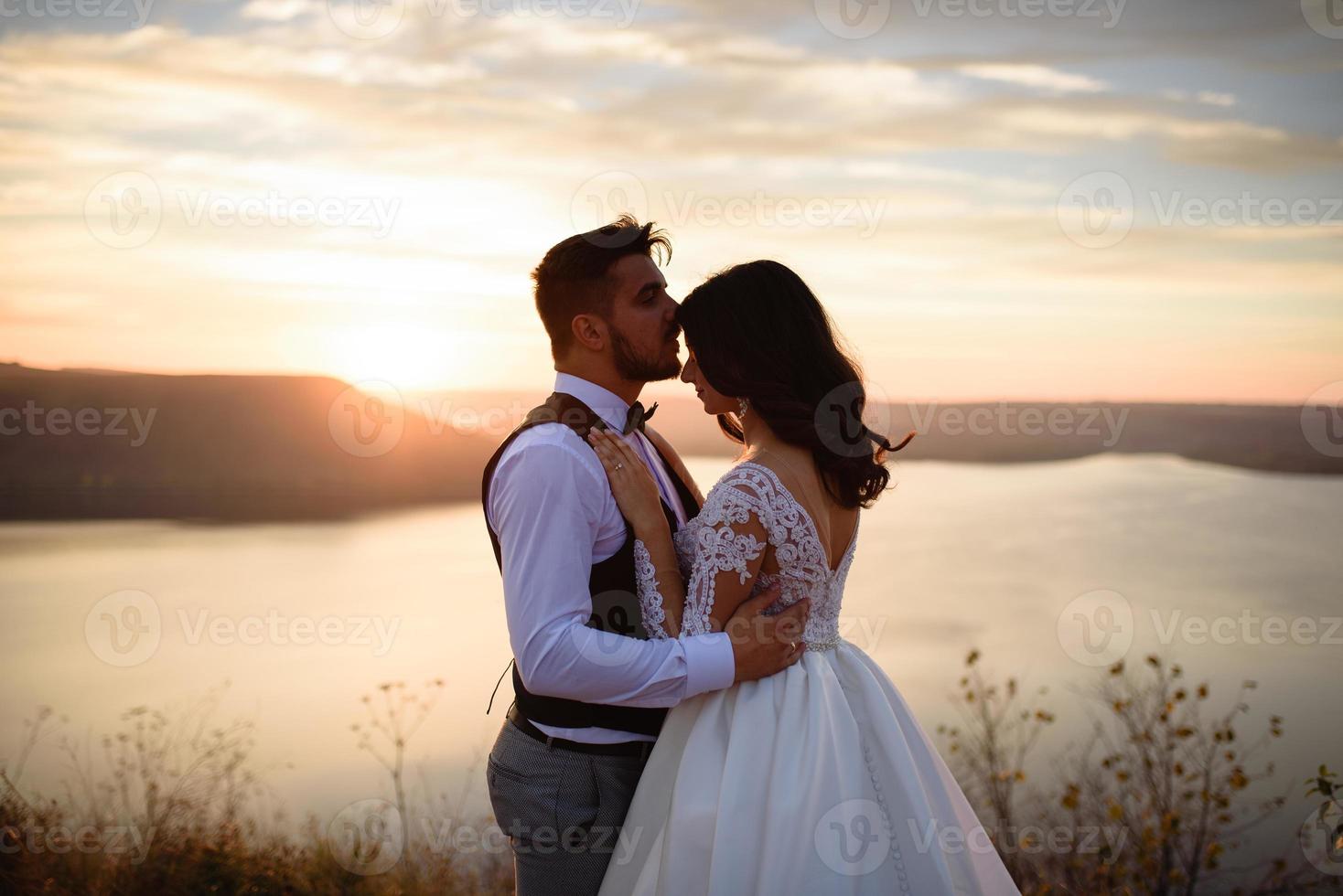 la mariée et le marié se promènent près du vieux château. le couple se tient dos à l'autre. photo