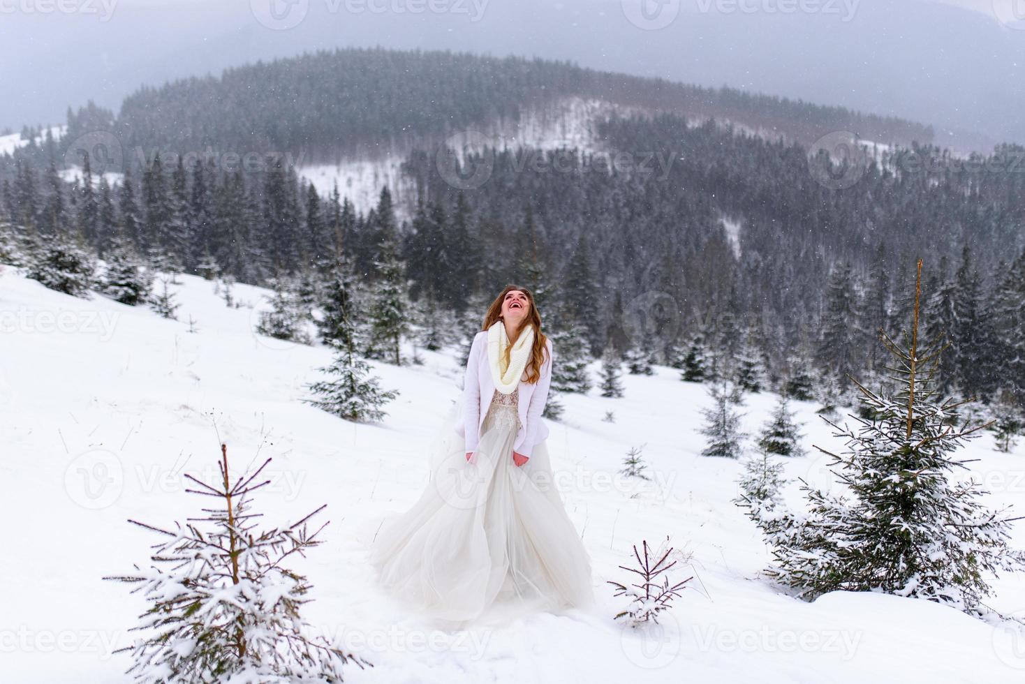 le marié conduit sa fiancée par la main jusqu'à un vieux hêtre solitaire. mariage d'hiver. place pour un logo. photo