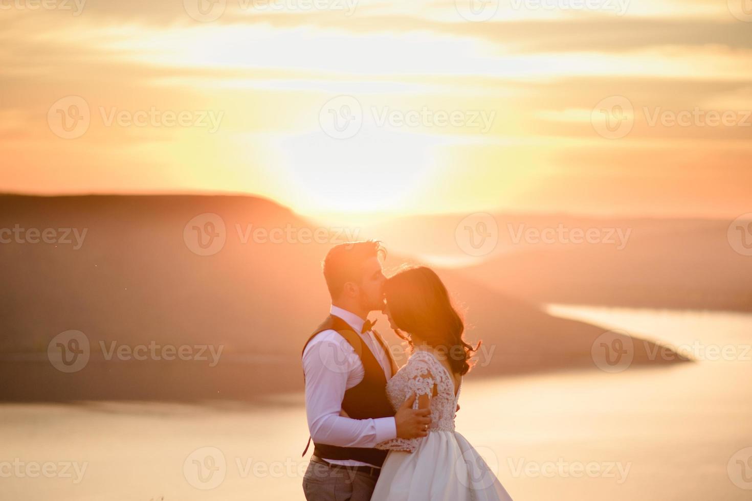 la mariée et le marié se promènent près du vieux château. le couple se tient dos à l'autre. photo