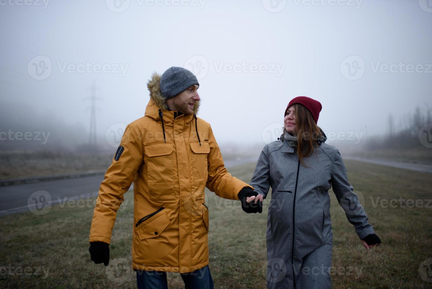 un couple enceinte aimant se promène à l'extérieur de la ville à la fin de l'automne. photo