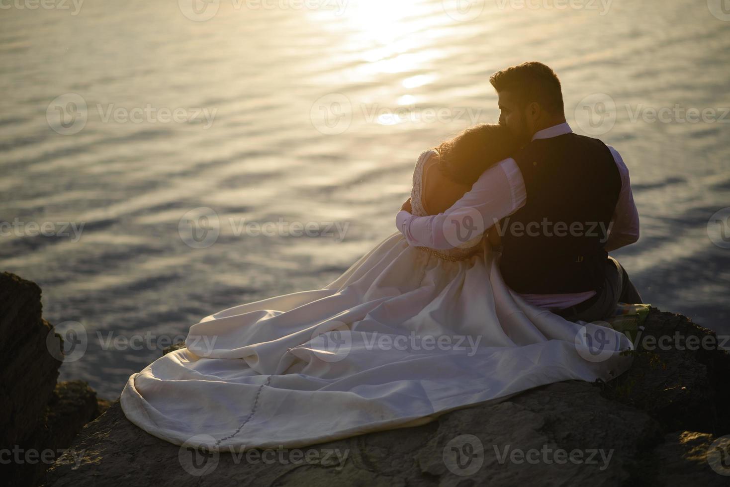 la mariée et le marié se promènent près du vieux château. le couple se tient dos à l'autre. photo