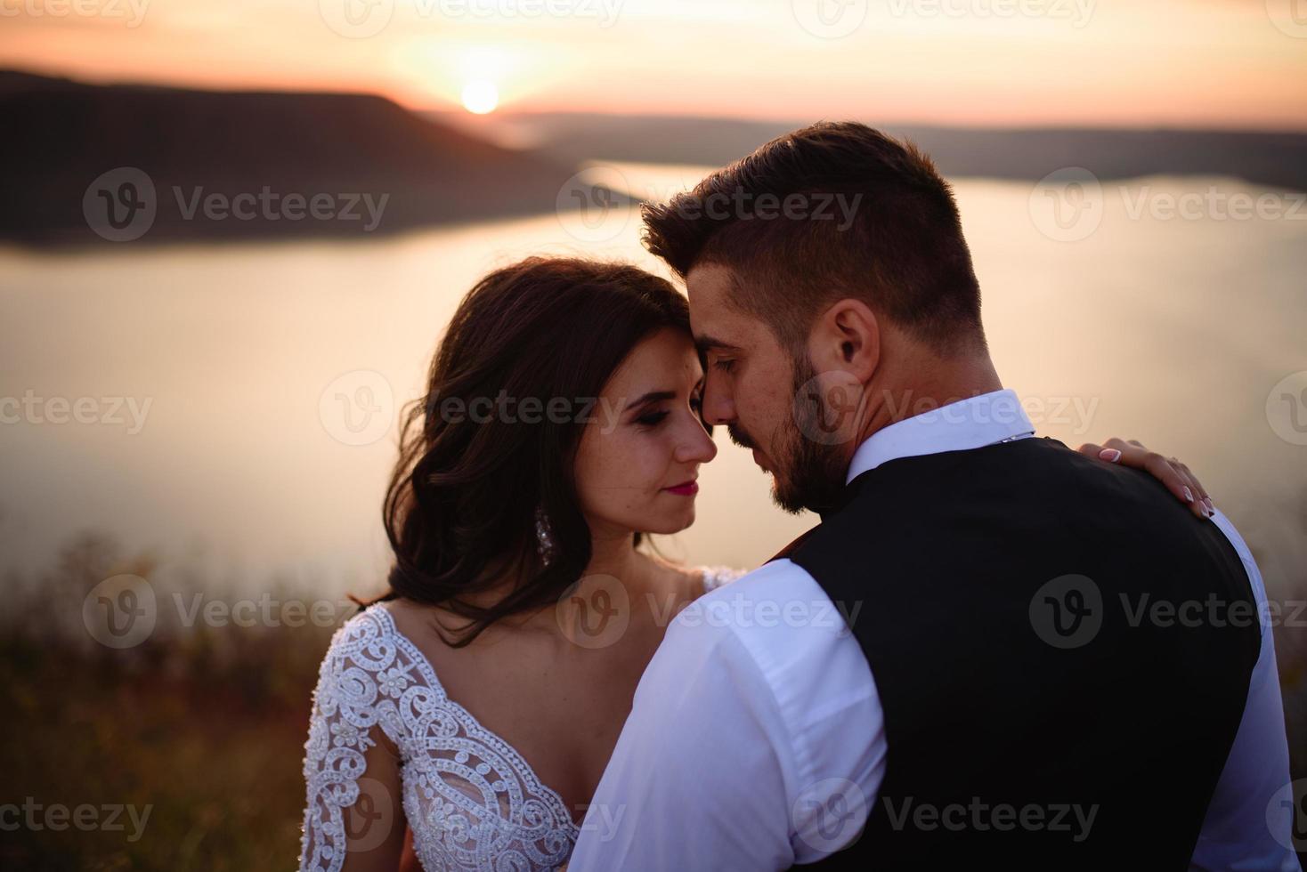 la mariée et le marié se promènent près du vieux château. le couple se tient dos à l'autre. photo