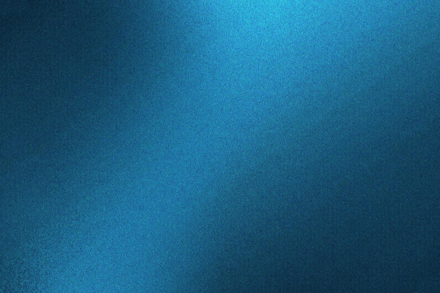 lumière qui brille sur un mur métallique bleu dans une pièce sombre, fond de texture abstraite photo