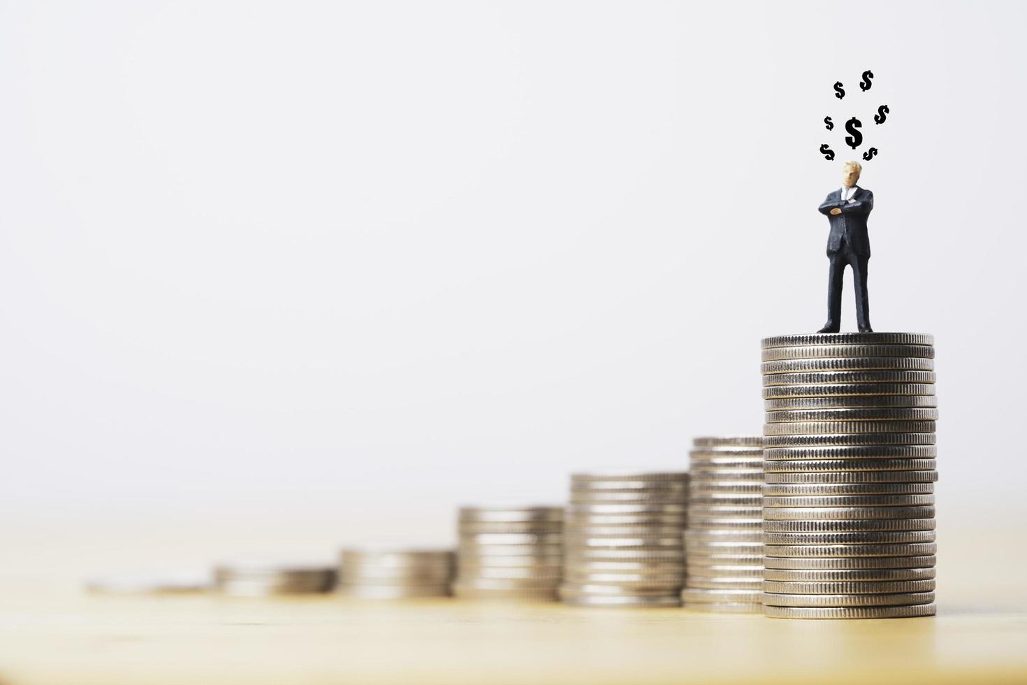 homme d'affaires debout sur des pièces de croissance empilées avec le signe dollar pour l'expansion des affaires et le concept de croissance des bénéfices. photo