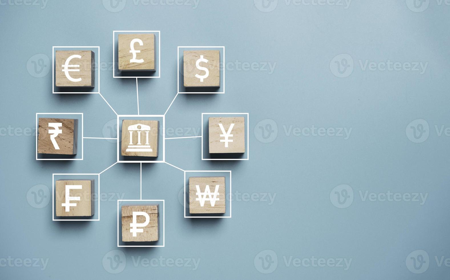 banque centrale et icônes multi-devises impriment l'écran sur un bloc de cube en bois et une ligne de connexion pour le concept de change et de transfert d'argent. photo