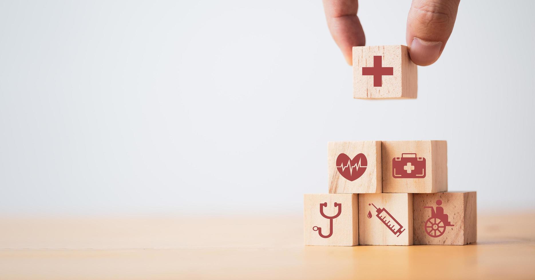 médecin mettant et empilant un cube de bloc de bois qui imprime des soins de santé à l'écran et des icônes médicales pour un concept de santé et de bien-être. photo