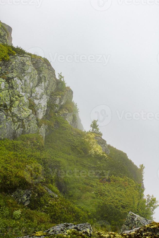 brouillard, nuages, rochers et falaises sur la montagne veslehodn veslehorn, norvège. photo